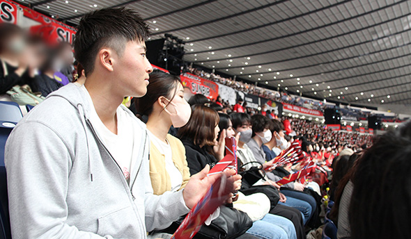 Vリーグ決勝戦を視察する佐々木さん（左）と田蔵ゼミメンバー